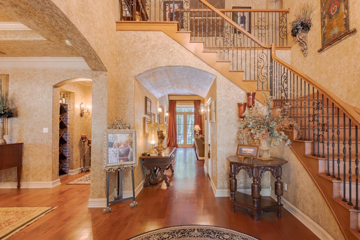 Grand Country French custom home entryway with curved staircase and hardwood flooring by Bort Design in Longview, TX.-optimized