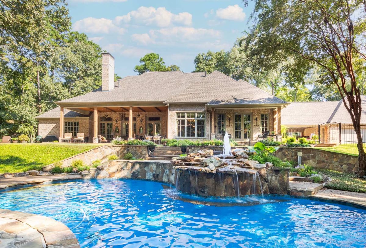 Luxury outdoor living space featuring a pool, covered patio, and custom home design by Bort Design in Longview, TX.-optimized