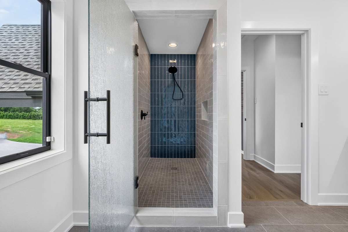 bathroom shower entrance with textured glass door in longview texas custom home