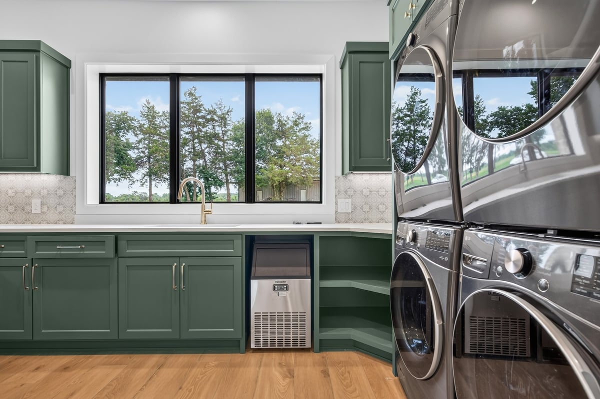 close up of green shaker kitchen cabinets with brass pulls in longview texas custom home