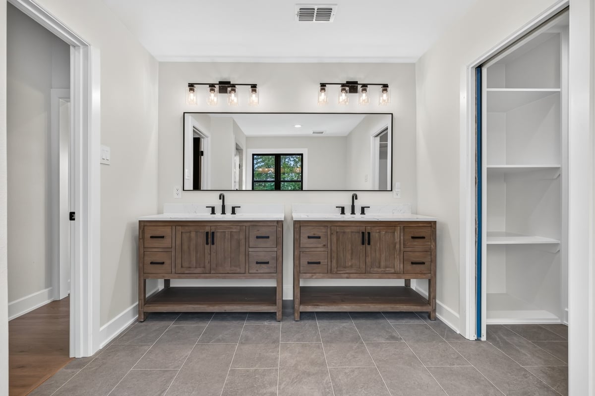 double vanity bathroom with wood cabinetry in longview texas custom home