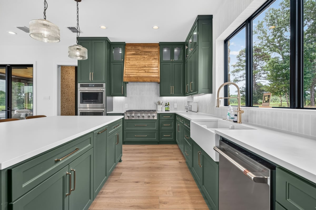 green custom kitchen with farmhouse sink and wood vent hood in longview texas custom home