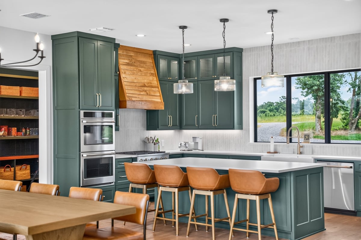 green custom kitchen with island seating and wood vent hood in longview texas custom home