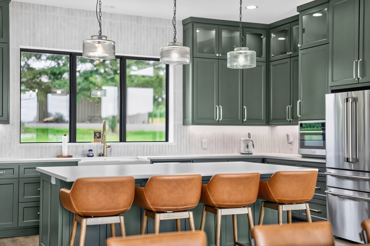 green custom kitchen with large island and leather bar stools in longview texas custom home