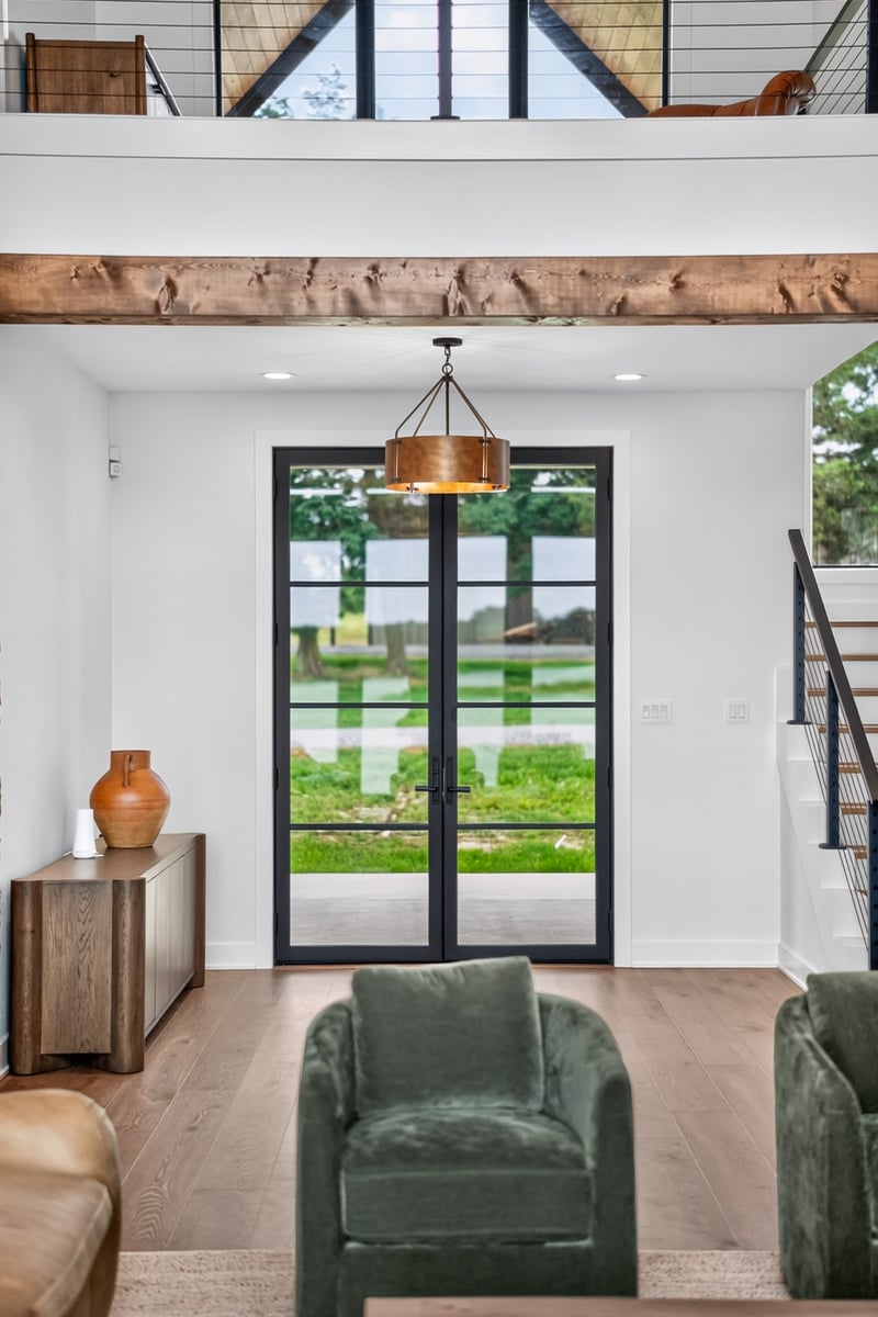 living room view toward black framed exterior doors in longview texas custom home