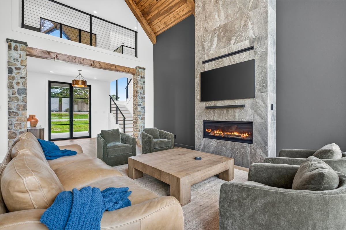 living room with stone fireplace and vaulted ceiling in longview texas custom home