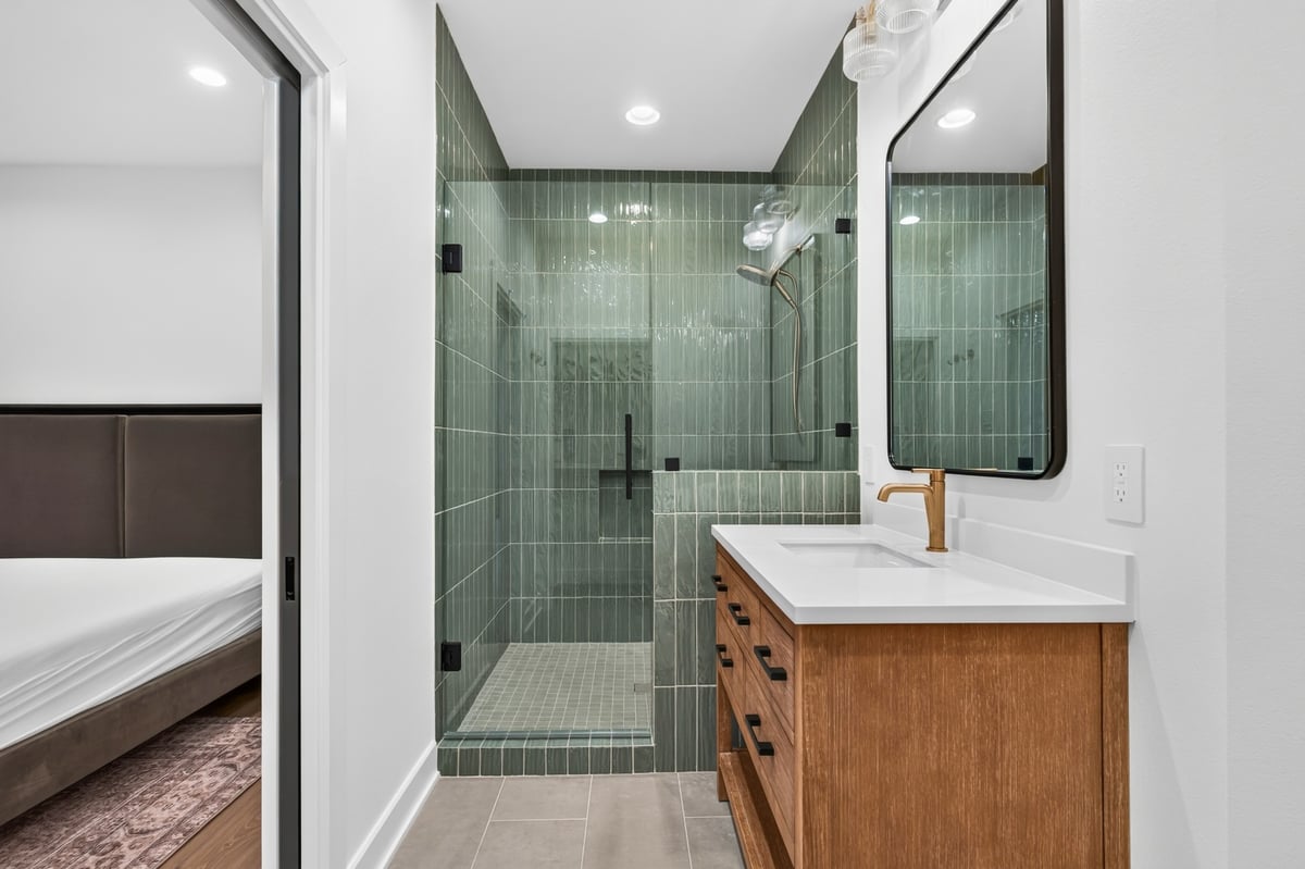modern bathroom vanity with green tile walk in shower in longview texas custom home
