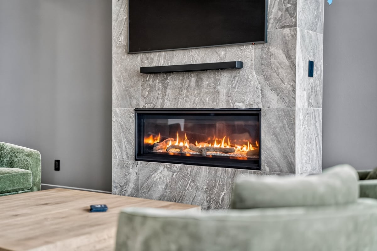 modern fireplace with stone surround and linear gas insert in longview texas custom home