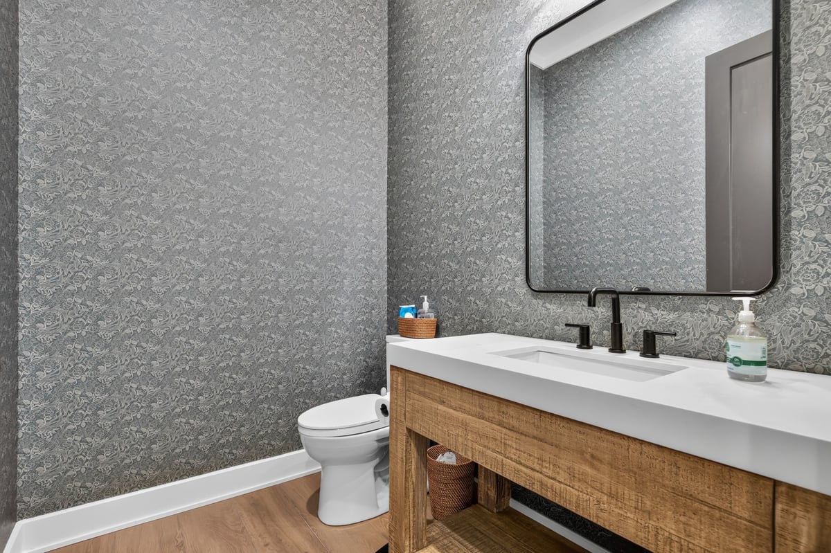 powder bathroom with patterned wallpaper and wood vanity in longview texas custom home