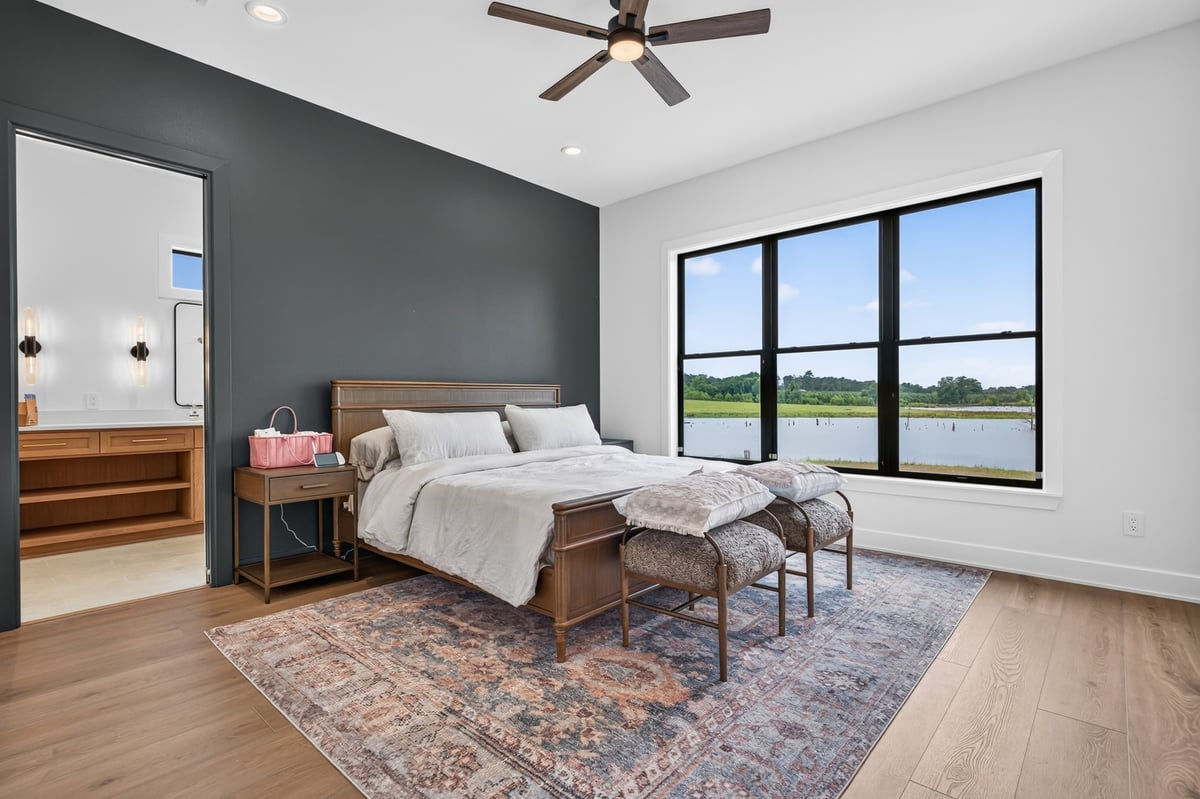 primary bedroom with black accent wall and lake view in longview texas custom home