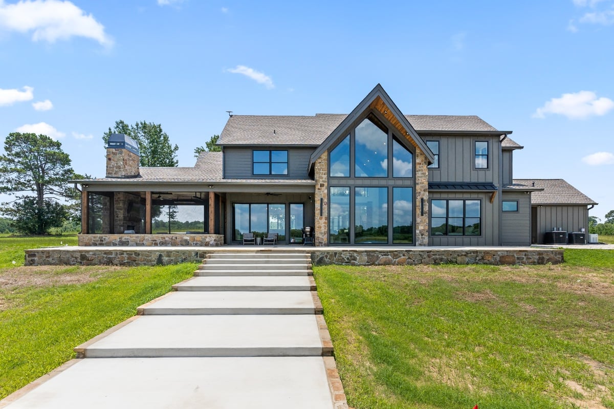 rear exterior with stone facade and large picture windows in longview texas custom home