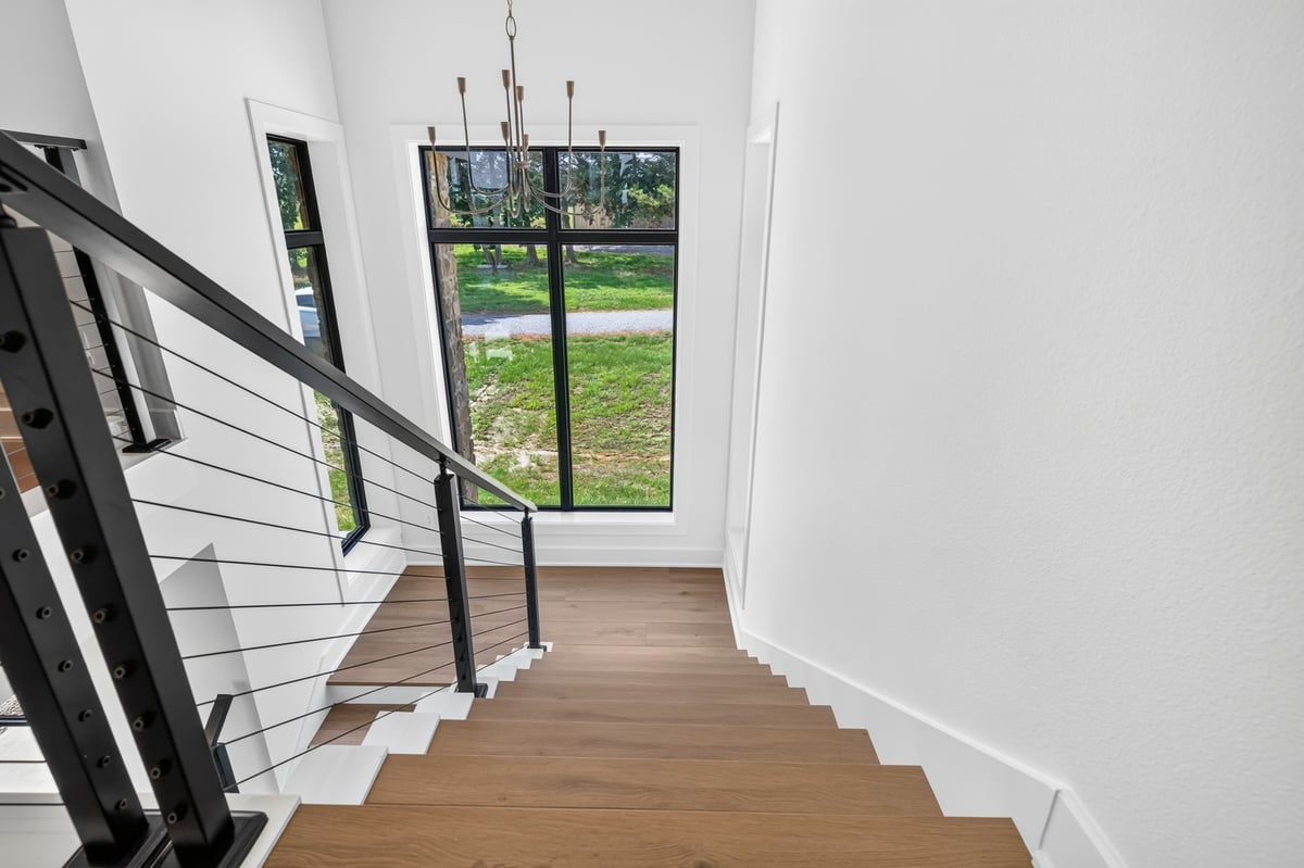 staircase with wood treads and black cable railing in longview texas custom home