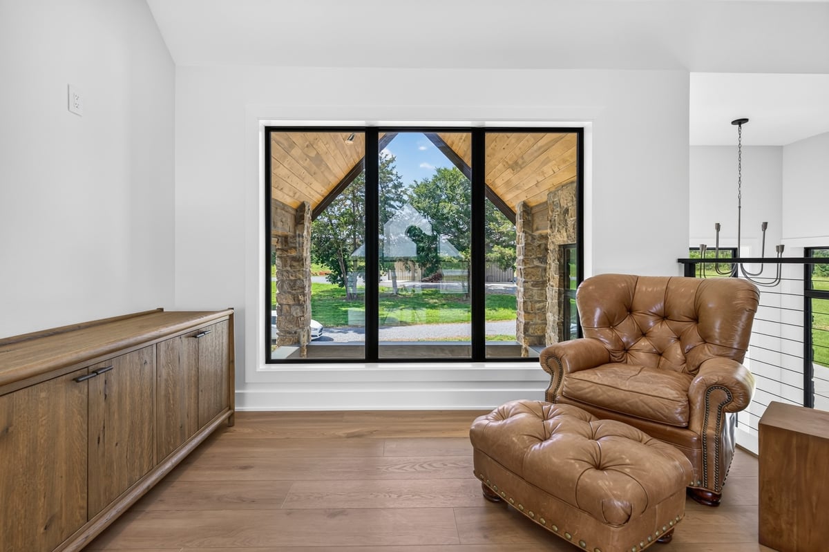 upstairs reading nook with leather chair and picture window in longview texas custom home