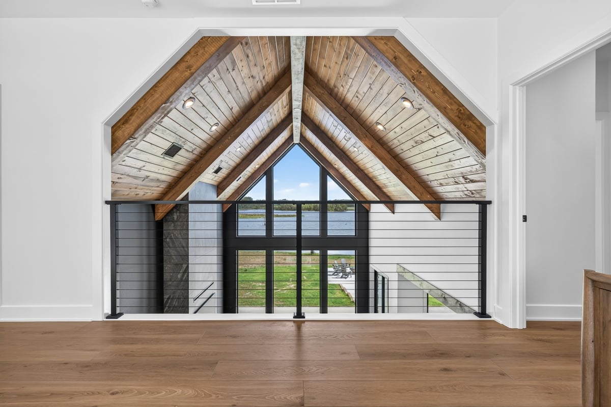 vaulted loft overlook with lake view window wall in longview texas custom home