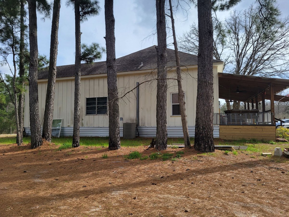 before east texas home remodel side exterior among pine trees covered patio bort custom homes