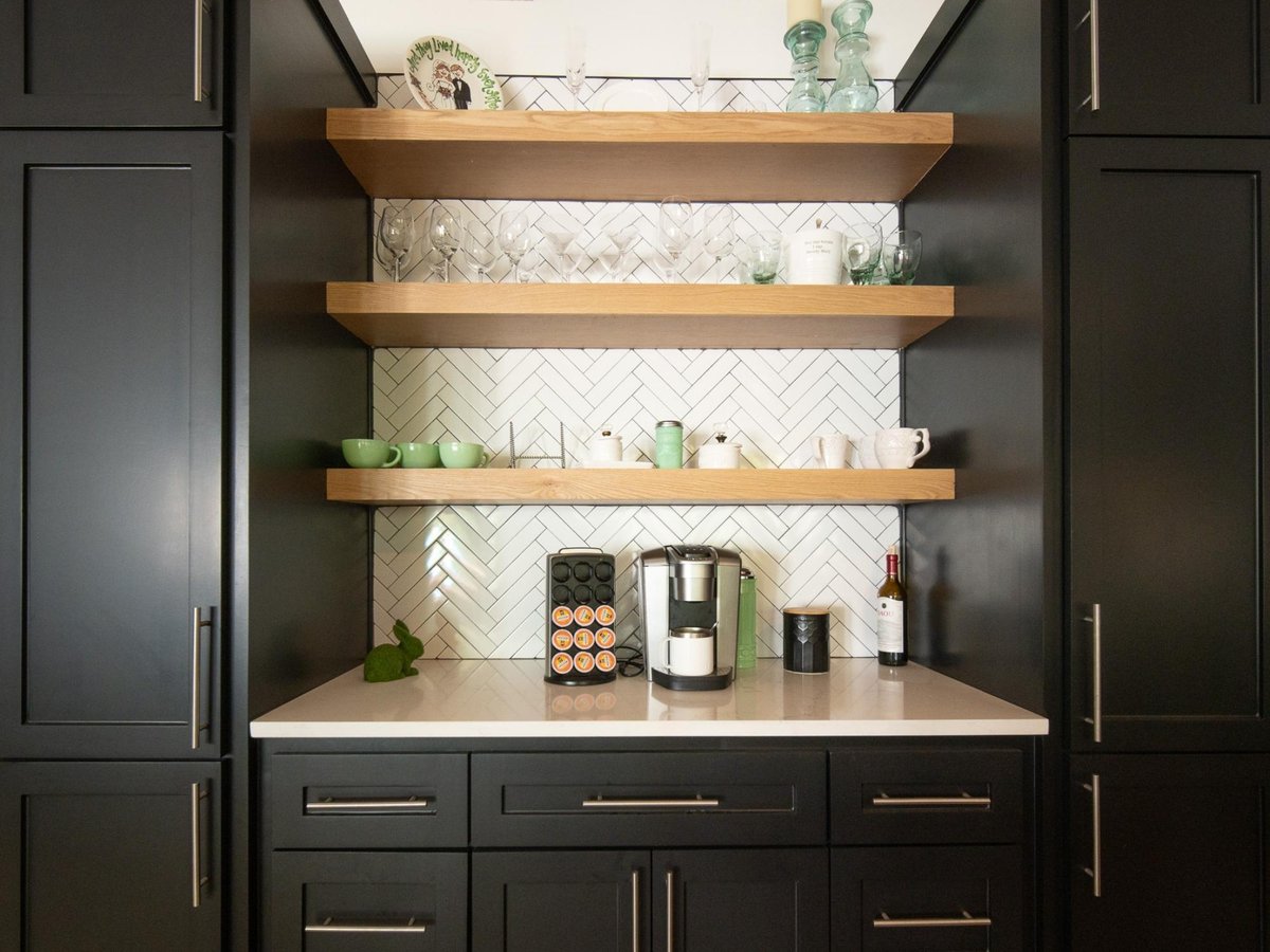 Photo of a custom coffee bar with black cabinets, wood shelves, and herringbone backsplash in an East Texas kitchen.