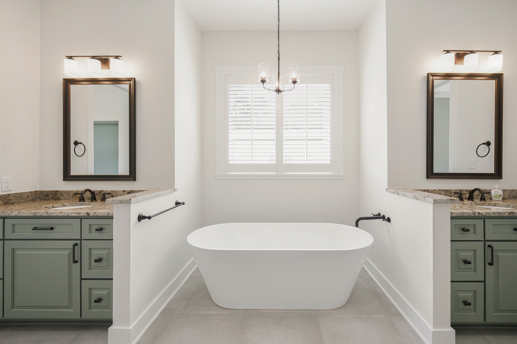 Freestanding tub set between two vanities in a Henderson, TX bathroom designed and built by Bort Custom Homes.
