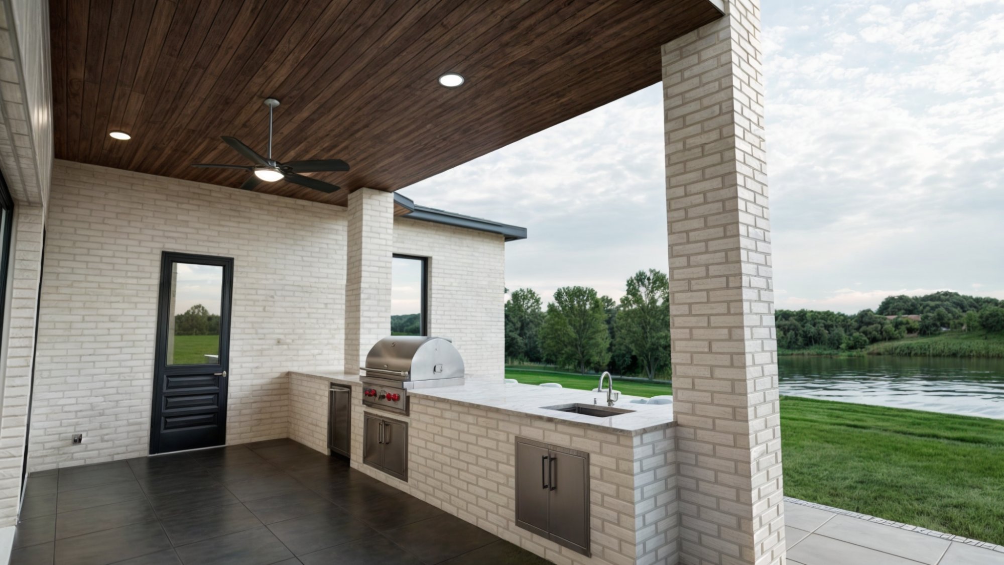 Contemporary custom home patio showcasing an outdoor kitchen and relaxing waterfront views by Bort Design in Longview, TX.-optimized
